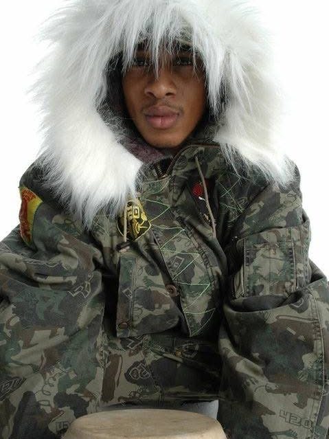 A model in a camo jacket with a fur-trimmed hood