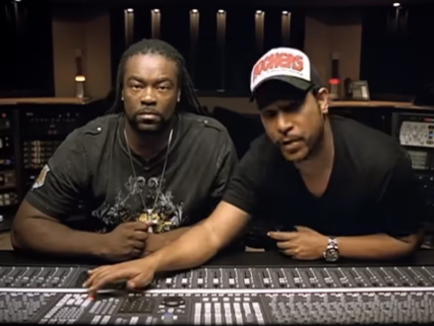 Two engineers at a mixing console in a recording studio
